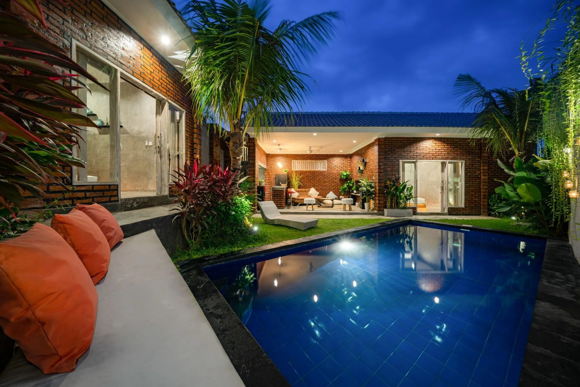 Bespoke outdoor living space featuring a tranquil pool, landscaped garden with vibrant plants, and modern seating area, highlighting custom woodwork and carpentry design elements.